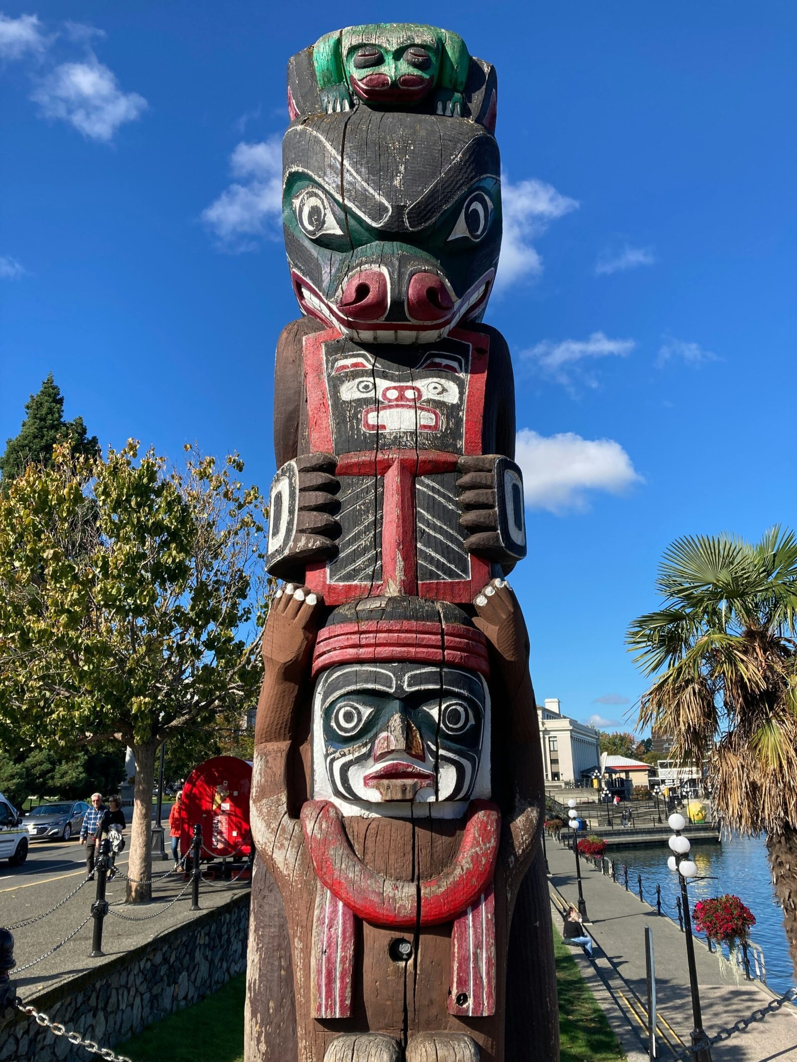 a statue of a totema in a park next to a body of water